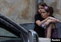 Local residents react at a site of a residential building hit by a Russian missile strike, amid Russia's attack on Ukraine, in Lviv, Ukraine, July 6, 2023.
