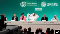 2023年12月8日，在阿拉伯联合酋长国迪拜举行的COP28联合国气候峰会新闻发布会上，COP28主席苏丹·埃尔-贾比尔（中）调整他的头巾。（美联社照片）