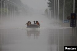 中国河北涿州民众在滔滔洪水中乘坐橡皮艇逃生。（2023年8月3日）