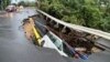 A vehicle is stuck in a collapsed section of road in Hong Kong on Sept. 8, 2023. 