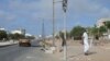 Un piéton passe devant un feu de signalisation brisé dans une rue de Dakar le 3 juin 2023, suite aux violences meurtrières dans la capitale sénégalaise (Photo by Seyllou / AFP)