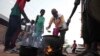 People prepare food in a Khartoum neighborhood Friday, June 16, 2023.