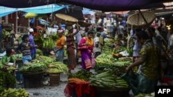 ঢাকার কারওয়ান বাজারের সবজি বাজারের মধ্য দিয়ে হেঁটে যাচ্ছেন একজন বাংলাদেশি নারী। (ফাইল ছবি) 