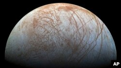 This image made available by NASA in 2014 shows Jupiter's icy moon Europa in a reprocessed color view, made from images captured by NASA's Galileo spacecraft in the late 1990s. (NASA/JPL-Caltech/SETI Institute via AP)