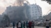 FILE - Journalists observe as Palestinians inspect the rubble of a building after it was struck by an Israeli airstrike, in Gaza City, Oct. 8, 2023.