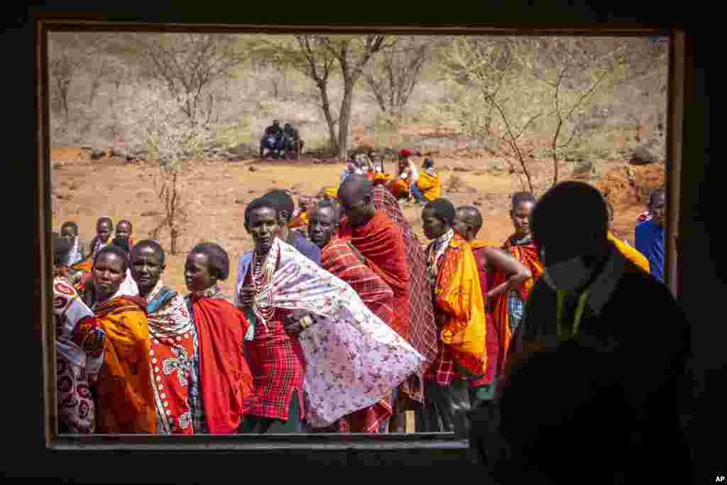 Maasai, waiting in line to cast their votes, look through an open window at electoral officials who are inside a polling station at the Niserian Primary School, in Kajiado County, Kenya.