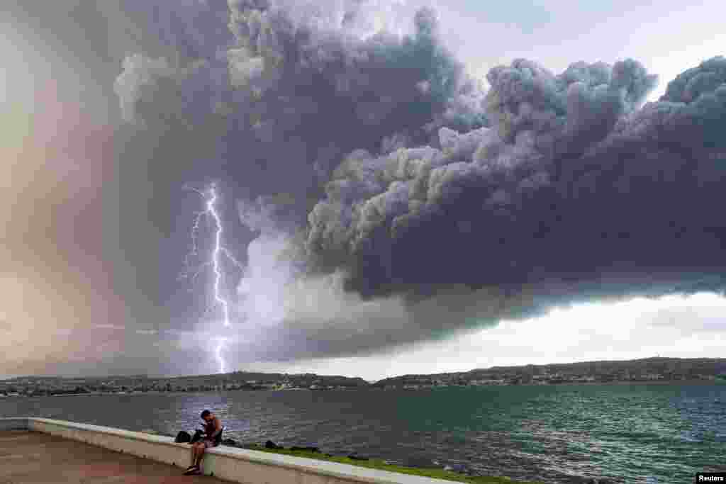 Lightning strikes through clouds and smoke from fuel storage tanks that exploded near Cuba&#39;s supertanker port in Matanzas, Cuba, Aug. 8, 2022.