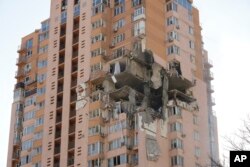 An apartment building damaged following a rocket attack on the city of Kyiv, Ukraine, Saturday, Feb. 26, 2022. Russian troops stormed toward Ukraine's capital Saturday, and street fighting broke out as city officials urged residents to take shelter. (AP Photo/Efrem Lukatsky)