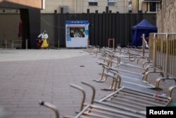 身穿防护服的工作人员在等候上海市民前来做新冠核酸检测。（2022年12月22日）