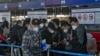 北京国际机场一个国际航班柜台排队的手持中国护照的乘客。（美联社2022年12月29日）