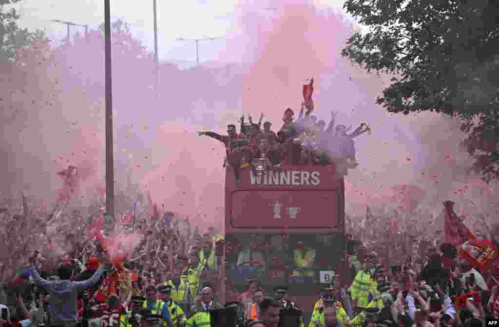 Liverpool&#39;s players celebrate&nbsp;winning the 2021-22 League Cup and FA Cup from an open-top bus with supporters during a parade through the streets of Liverpool in north-west England.