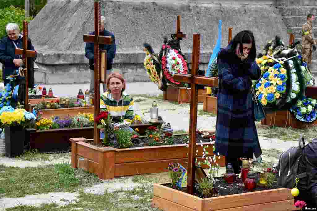 People pay respect to graves at Lychakiv Cemetery where some people killed in Russia&#39;s invasion of Ukraine are buried as the Day of Heroes of Heavenly Hundred is celebrated in Lviv, Ukraine.