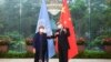 In this photo released by Xinhua News Agency, Chinese Foreign Minister Wang Yi, right, poses for photo with the United Nations High Commissioner for Human Rights Michelle Bachelet in Guangzhou, in southern China's Guangdong province, May 23, 2022.