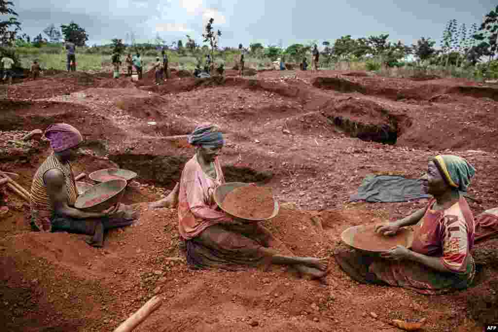Tanzanian miners Mwagyma Ramadhan, Regina Daud and Maria Ng&#39;ombe look for gold at an open-pit gold mine in Nyarugusu, Geita Region.