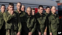FILE - Russian recruits stand waiting to take a train at a railway station in Prudboi, Volgograd region of Russia, Sept. 29, 2022. 