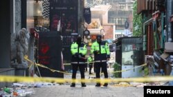 Police stand guard at the scene where a stampede during Halloween festivities killed and injured many people at the popular Itaewon district in Seoul, South Korea, Oct. 30, 2022. (Yonhap/Reuters)