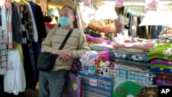 A vendor wears a face mask and waits for customers at a night market in Taipei, Taiwan, Thursday, Feb. 6, 2020. According to the Taiwan Centers of Disease Control (CDC) Thursday, the thirteenth case diagnosed with the 2019 novel coronavirus (2019…