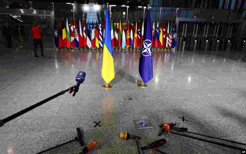Members of the media prepare their microphones as they wait for the arrival of Ukraine&#39;s Foreign Minister Dmytro Kuleba and NATO Secretary General Jens Stoltenberg at a meeting of NATO foreign ministers at NATO headquarters in Brussels.