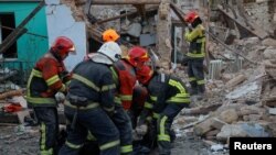Rescuers carry the body of a woman found under debris of a residential house destroyed by a Russian missile attack in Mykolaiv, Ukraine Nov. 1, 2022.