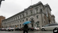 A woman crosses the street outside of the 9th U.S. Circuit Court of Appeals in San Francisco, Feb. 8, 2017. A federal appeals court will decide by end of day Thursday whether to reinstate President Donald Trump's controversial travel ban.