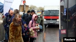 Wakimbizi wa Ukraine wanaokimbia uvamizi wa Russia nchini mwao wakisubiri kupanda basi linaloelekea mjini Przemysl, baada ya kuvuka mpaka wa Ukraine-Poland, Medyka, Poland, April 1, 2022. REUTERS/Hannah McKay