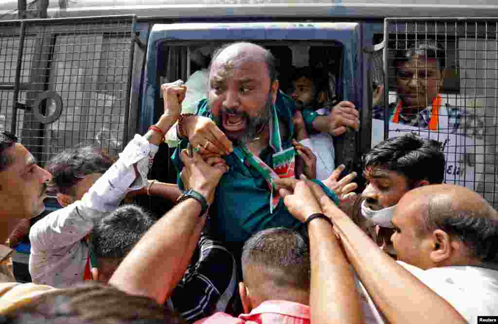 A supporter of India&#39;s main opposition Congress party shouts from a police vehicle as he is detained during a protest against the rise in fuel prices, in Ahmedabad, India.
