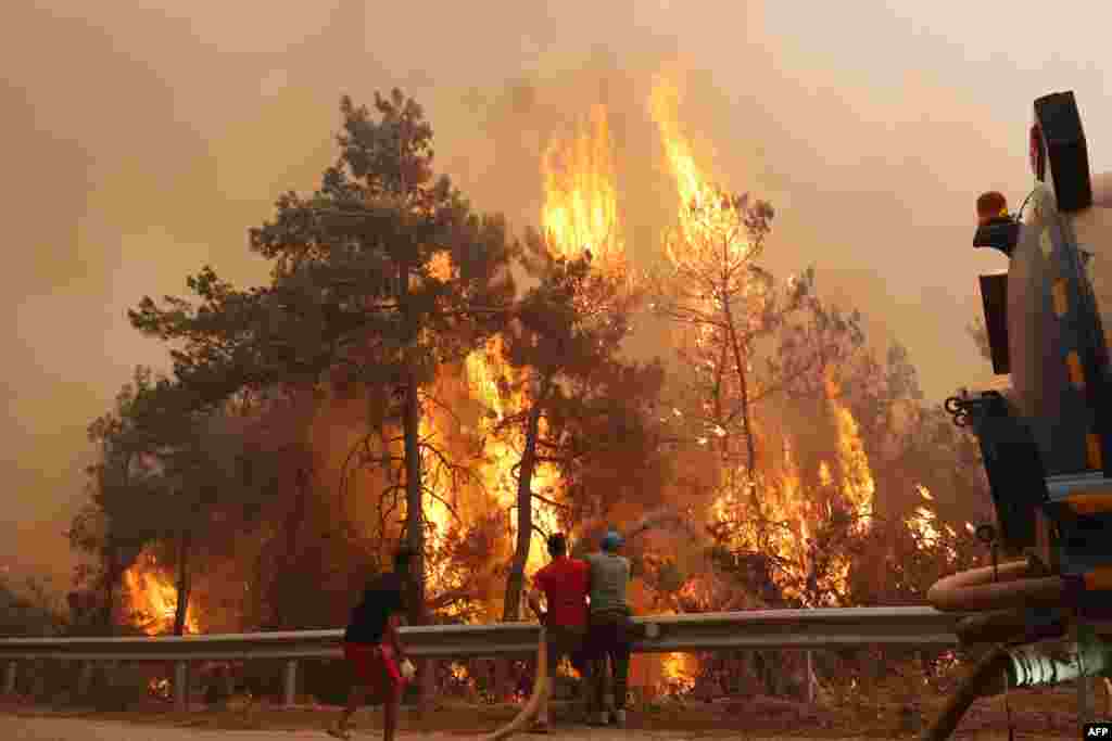 Volunteers help to extinguish a wildfire that broke out in the Datça district of Mugla, Turkey.