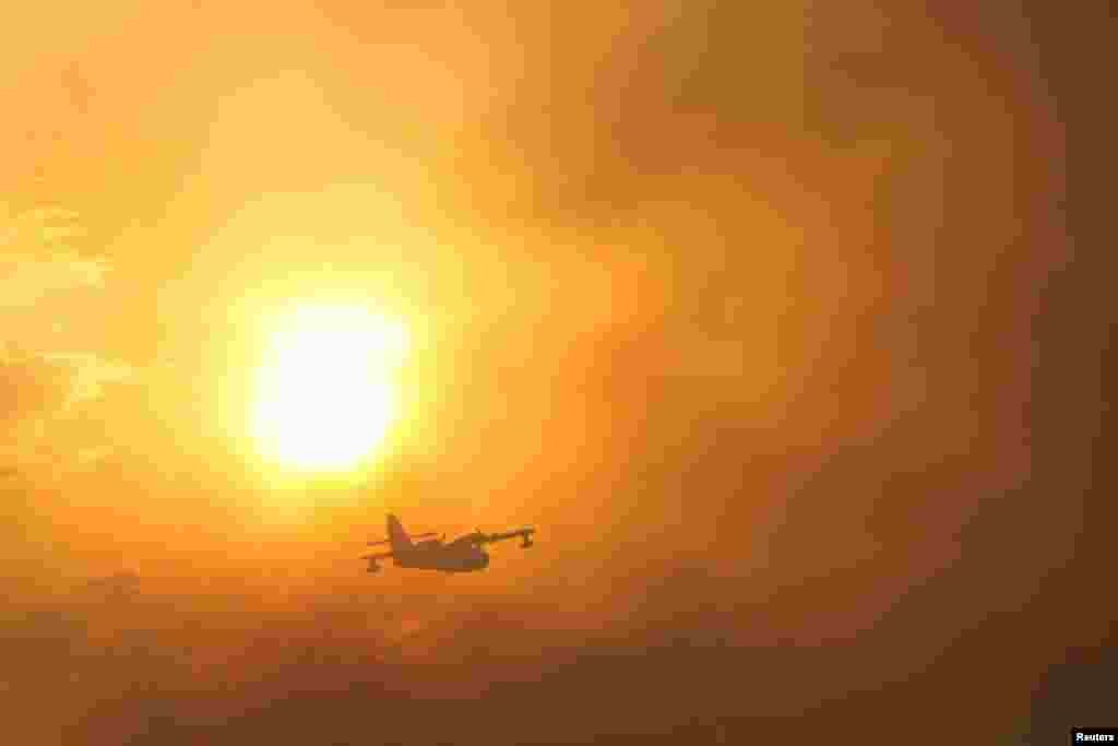 A plane flies over a wildfire in Ourem, Santarem district, Portugal, July 12, 2022. 