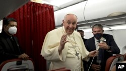 Papa Francis akiwasalimia waandishi wa habari ndani ya ndege wakati wa safari ya kurudi mjini Roma baada ya ziara yake ya siku mbili ya kuhubiri mjini Malta, April 3, 2022. Picha ya AP..