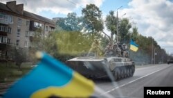 Ukrainian service members ride on an armored fighting vehicle in the town of Kupiansk, recently liberated by the Armed Forces, amid Russia's attack on Ukraine, in Kharkiv region, Ukraine, in this handout picture released Sept. 19, 2022. (Ukrainian Preside