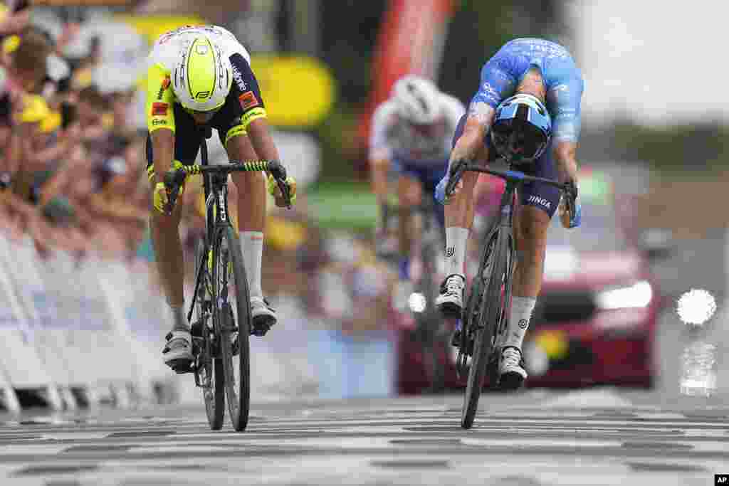 Stage winner Australia&#39;s Simon Clarke, right, pushes his wheel over the finish line ahead of Netherlands&#39; Taco van der Hoorn during the fifth stage of the Tour de France cycling race over 157 kilometers (97.6 miles) with start in Lille Metropole and finish in Arenberg Porte du Hainaut, France.