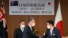澳大利亚国防部长马勒斯和日本防务大臣岸信夫在东京举行联合记者会后握手。（2022年6月15日）