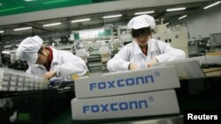 Employees work inside a Foxconn factory in the township of Longhua in the southern Guangdong province in this May 26, 2010 file photo.