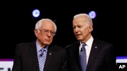 From left, Democratic presidential candidates, Sen. Bernie Sanders, I-Vt., former Vice President Joe Biden, talks before a Democratic presidential primary debate, Tuesday, Feb. 25, 2020, in Charleston, S.C. (AP Photo/Matt Rourke)