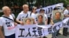 2018年8月6日，人们在中国广东省深圳市坪山区燕子岭派出所外示威，手持标语，支持佳士工厂工人。