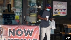 A customer walks past a now hiring sign at an eatery in Richardson, Texas, Sept. 2, 2020. 
