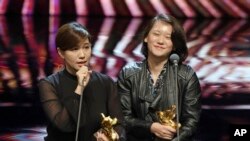 在台湾台北举行的第55届金马奖典礼上，台湾导演傅榆（左）以《我们的青春，在台湾》获最佳纪录片奖，发表获奖感言（2018年11月17日）。）