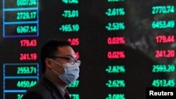 FILE PHOTO: A man wearing a protective mask is seen inside the Shanghai Stock Exchange building, as the country is hit by a new coronavirus outbreak, at the Pudong financial district in Shanghai