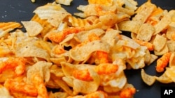 A mixture of salty snacks and chips is shown left on a table in Pittsburgh's Market Square on Tuesday, Feb. 7, 2012. In a government report released Tuesday, Feb. 7, 2012, that includes a list of the top 10 sources of sodium. Salty snacks actually came…
