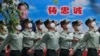 北京街头一队武警士兵走过习近平的宣传画。（2020年5月25日）