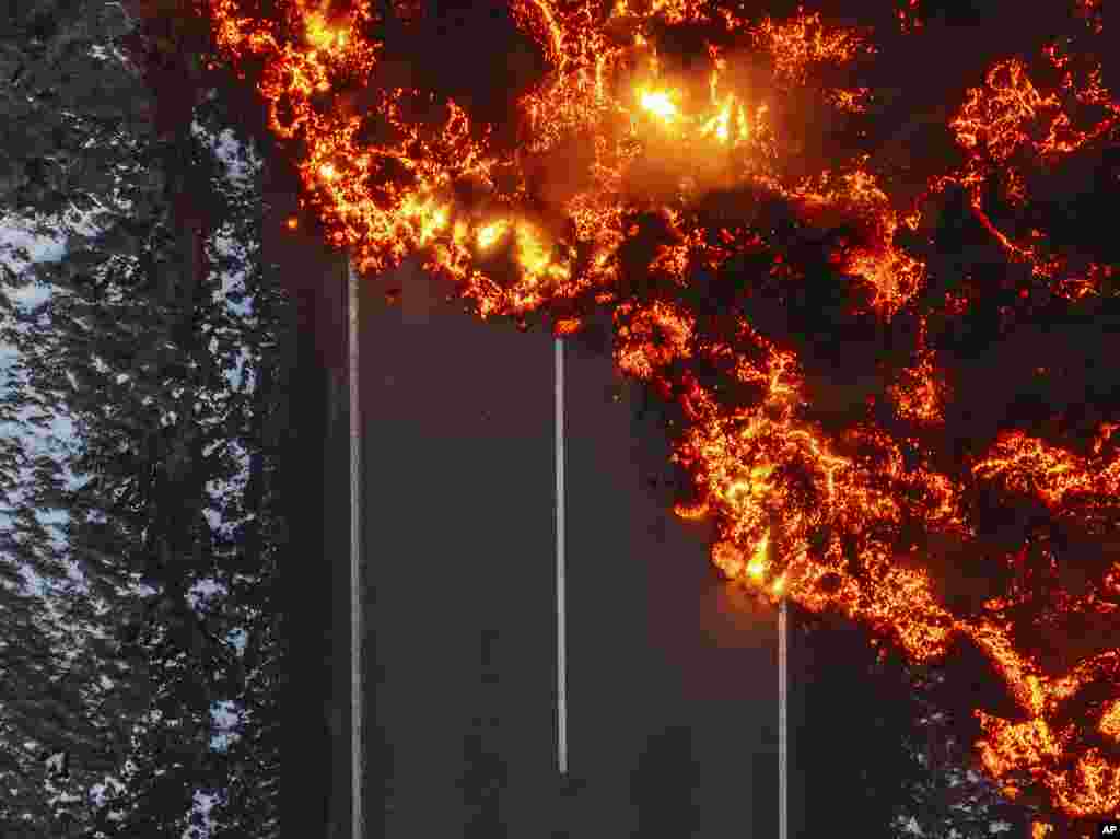 Molten lava flows on the road to the Blue Lagoon, Grindavik, after the volcanic eruption that started Wednesday, on the Reykjanes Peninsula in Iceland, Nov. 21, 2024.&nbsp;(AP Photo/Marco di Marco)