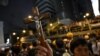 FILE - A protester holds a Christian cross as others gather outside the police headquarters in Hong Kong, June 21, 2019.