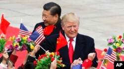 美国总统川普（右）和中国国家主席习近平在北京人大会堂举行的欢迎仪式上受到挥舞美中两国国旗和鲜花的孩子们的欢迎。（2017年11月9日）