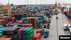 Workers are seen among the containers at Asia World port in Yangon, Myanmar, July 2, 2014. 