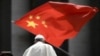 当教宗方济各在梵蒂冈圣彼得广场结束对信众的每周讲话离开时，一人向他展示中国国旗。（2019年6月12日）
