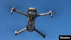 FILE PHOTO: A drone is seen in the sky as Chinese drone maker DJI holds a demonstration to display an app that tracks a drone's registration and owner in Montreal