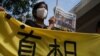 在西九龙法院的一次听证期间，一名支持者举着报纸在法院外声援《苹果日报》。(2021年6月19日)