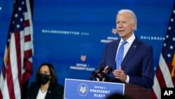 FILE - President-elect Joe Biden speaks as Vice President-elect Kamala Harris, left, listens during an event to introduce their future administration's nominees and appointees, at The Queen theater in Wilmington, Delaware, Dec. 1, 2020. 