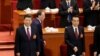 在北京人民大会堂举行的全国人大代表大会开幕式的主席台上，中国前反腐“沙皇”王岐山在习近平主席和李克强总理身后走过。