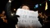 2024年12月4日，韩国总统尹锡烈宣布戒严后，人们聚集在首尔国会大厦，一个人举着一块写着“民主不会向尹锡烈屈服”字样的标语牌。
